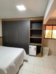 1 dormitorio con 1 cama y nevera pequeña en Casa De Temporada Mandacaru, en Piranhas
