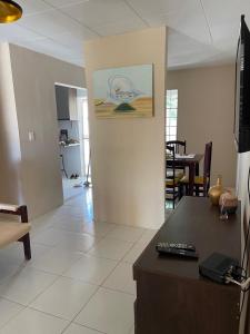 una sala de estar con una mesa con una foto en la pared en Casa De Temporada Mandacaru, en Piranhas
