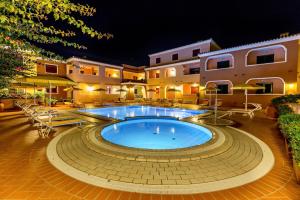 a swimming pool in front of a building at night at Residence with swimming-pool in Sos Alinos in Orosei +14 photos