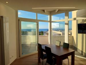テッラジーニにあるHolidayHouse Belvedereのテーブルと大きな窓のあるダイニングルーム