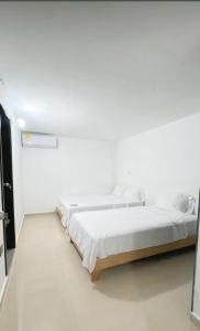 巴耶杜帕尔ARY Hotel的一间白色客房,内配两张床