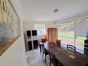 a dining room with a table and a large window at 188 On Springs Road in Brakpan