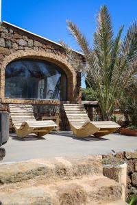 two lounge chairs sitting in front of a building at Bouganville- Le casette di Marilena in Pantelleria