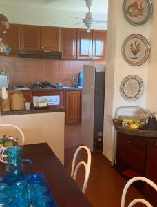 Una cocina con una mesa con sillas y un refrigerador. en VILLA VIDA, en Saline Joniche 5 fotos más