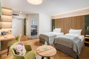 a hotel room with two beds and a table at Parkhotel Güldene Berge in Weißenfels