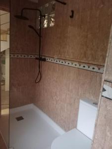 a bathroom with a white toilet and a shower at La Herrería de Somo in Somo