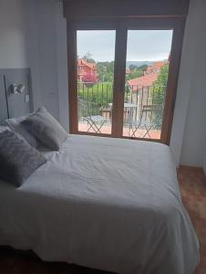 a bed in a room with a large window at La Herrería de Somo in Somo