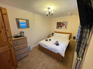 a small bedroom with a bed and a dresser at Admiral Blake Guesthouse in Bridgwater +5 photos