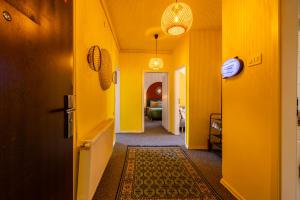 a hallway with yellow walls and a hallway with a rug at Sunny & Bright Central in Pristina