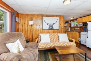 a living room with a couch and a table at Chippewa Bluffs Resort Combined 4BR 4BA Cabins in Barryton
