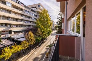 an apartment balcony with a view of a street at Sunny & Bright Central in Pristina