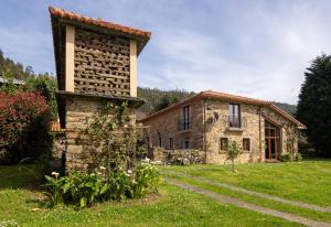 an old stone house in a grassy yard at Casa Balteira da Terra, Cedeira in Cedeira