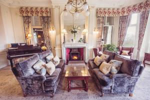 a living room with two couches and a fireplace at Merewood Country House Hotel in Windermere