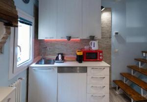 a kitchen with a sink and a red microwave at La Casa Gialla in Chioggia +15 photos