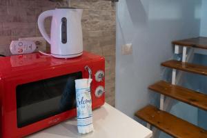 a blender sitting on top of a red microwave at La Casa Gialla in Chioggia