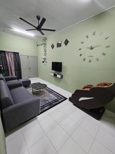 a living room with a couch and a clock on the wall at Syahar Homestay Temerloh in Temerloh