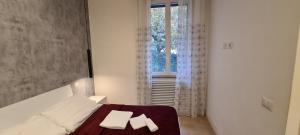 a bedroom with a bed with two pillows and a window at Trastevere incantevole con patio esterno privato in Rome