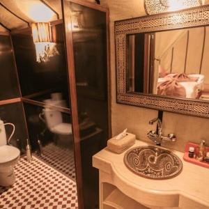 a bathroom with a sink and a mirror and a toilet at Brilliant luxury camp in Merzouga +22 photos