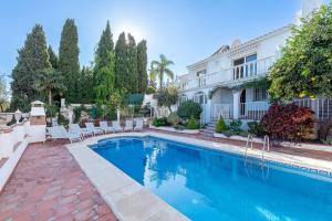 a swimming pool in front of a house at Luxury Villa Pomelo, Doña Pilar, Mijas in Mijas