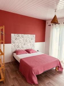 ル・タンポンにあるVilla A-Bleuの赤い壁のベッドルーム1室(大型ベッド1台付)