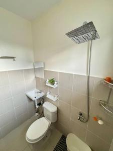 a bathroom with a toilet and a sink and a shower at Staycation Calaca in Calaca