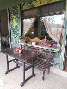 un banco de madera sentado frente a una ventana en Cabinas las Manzanas Bed y Breakfast, en Copey