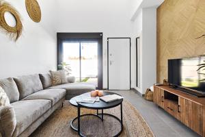 a living room with a couch and a tv at Casa Naranja in Pilar de la Horadada