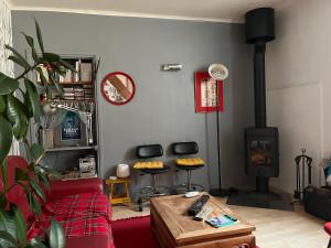 a living room with a red couch and a wood stove at Cosy House in Quimper