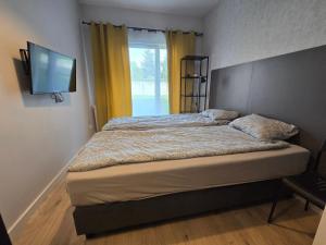 a bedroom with a bed with a television on the wall at ADLER Room Suite in Łódź
