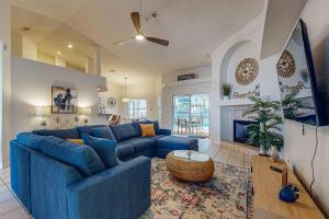 Una sala de estar con un sofá azul y una chimenea. en Casa Palmera, en Pensacola