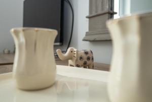 dwie wazy siedzące na stole z zabawką dla słonia w obiekcie Pinterest Apartment in the City Center w Sarajewie +29 zdjęć