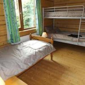 a bedroom with a bunk bed and a window at Hand built log cabin at Avonvale Holiday Lodges in Evesham