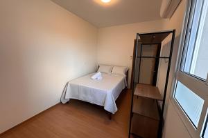a small bedroom with a bed and a window at Apartamento na praia, 2 quartos e área de lazer in Cabedelo +68 photos