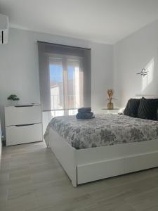 a white bedroom with a bed and a dresser at Apartamento Victoria Deluxe in Fuente Obejuna