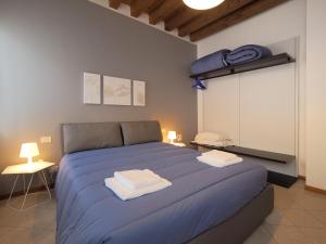 威尼斯的住宿－卡娜瑞格公寓- 威尼斯式公寓，一间卧室配有蓝色的床和2条毛巾