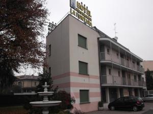 a building with a fountain in front of it at Hotel Residence La Fontana in Mariano Comense