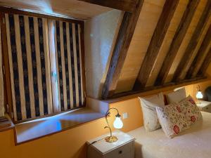 a bedroom with a bed with a lamp and a window at Le Chateau de Busqueilles La Suite in Autoire +7 photos