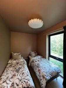 une chambre avec deux lits et une grande fenêtre dans l'établissement Efjord and Stetind Resort - Cabin Stetind, à Ballangen