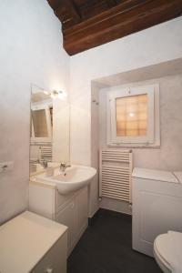 a bathroom with a sink and a toilet and a window at Trevi Fountain by BuddyRent in Rome