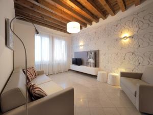 sala de estar con sofá y TV en Cannaregio - Venice Style Apartments, en Venecia