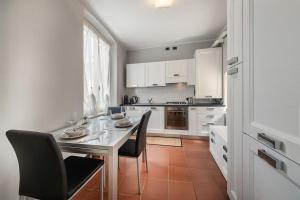 a kitchen with a table and chairs and a kitchen with white cabinets at Oasi in centro Bergamo - terrazza privata in Bergamo