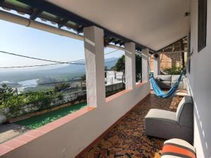 a balcony with a hammock and a view of the ocean at casa família in Rio de Janeiro