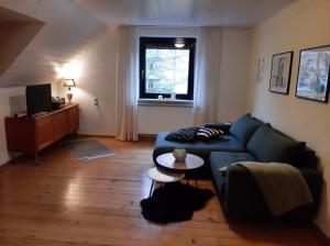 a living room with a blue couch and a table at Ferienwohnung Schäffer in Regensburg
