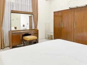 a bedroom with a desk and a mirror and a bed at Large Villa 3BR Cieumbuleuit near PVJ & Cihamplas by 2ndHome in Bandung