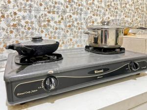 a stove with a pot on top of it at Large Villa 3BR Cieumbuleuit near PVJ & Cihamplas by 2ndHome in Bandung
