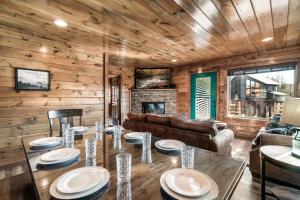 a dining room with a table and a couch at Luxury 5-BR Cabin Near Parkway and Dollywood with Game Room and Hot Tub in Pigeon Forge