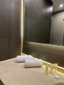 łazienka ze stołem z 2 kubkami i lustrem w obiekcie TAJ Hotel w Akabie