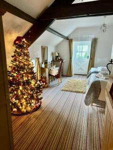 a christmas tree in the middle of a bedroom at Parr Cottage at Snape Castle Mews in Bedale