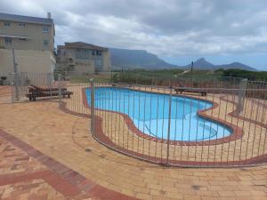 a swimming pool with a fence around it at 215 Sea View in Cape Town