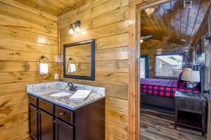 a bathroom with a sink and a mirror and a bed at Luxury 5-BR Cabin Near Parkway and Dollywood with Game Room and Hot Tub in Pigeon Forge +52 photos
